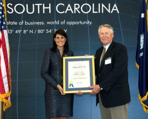 Cleve Nichols of US Fibers, accepts the Ambassador award on behalf of Edward S. Oh, with Gov. Haley.