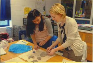 Ms. Katherine Vartanian (far left), art teacher at JET Middle School, assists her students in their clay-making.