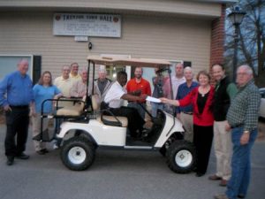 The Trenton Community Development Association presented the Trenton Council with a check for their portion of a donation that made possible the purchase of the golf cart in which Chief Of Police Deke Tanks is seated.  Kevin Corey from U.S. Fibers, another donor toward the purchase, joined Council and TCDA members in posing with the Town’s new golf cart.