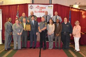 SCDPS Director Leroy Smith and SCDOT Acting Secretary Christy Hall present the award to Senator Shane Massey and Representative Bill Hixson, joined by other Edgefield County officials.