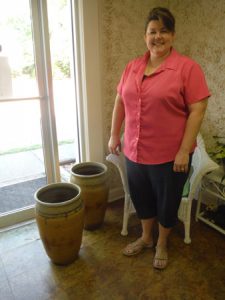 Here the Doggone Potter stands with two of her first pots, in her shop.