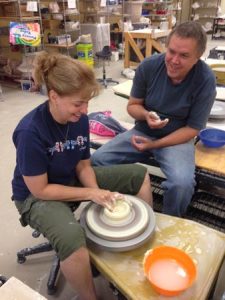 Laura Clifford works on clay that was mined in Edgefield and that she processed. Thomas Koole, Pottery Center Director, is instructing here.