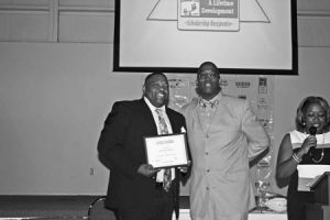 Mr. Calvin Henderson accepts his son’s Choices Scholarship from Mr. Errol Thomas.