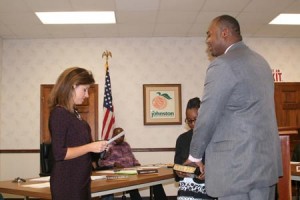 Jennifer Sumner administers the oath of office to Lamaz Robinson, Johnston's new Chief of Police.