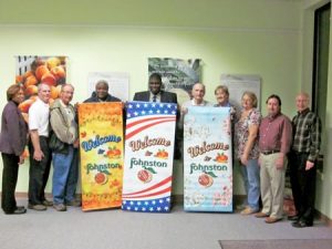 Johnston Mayor Terrence Culbreath (Center, holding banner) accepts the Johnston Development Corporation’s (JDC) donation of three banners for the downtown area. Members of the JDC Board are, from left, Goldie Dean, Tommy Stone, Chris Clancy, Noah Peterson, (Culbreath), Roger Lamb, Bridget Clark, Debra Aston, Frank Davis and Dean Campbell. Also on the JDC Board are Mary Anne Hair, Andy Livingston, Shane Massey, Don Smoak, John Timmerman and Ann Yonce.