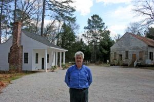 The new resident caretaker, Barney Lamar, standing before Horn’s Creek Church and the new caretaker’s cottage.