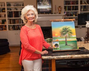Virginia Culbertson shows off a painting in progress, a palmetto tree based on a photograph taken by friend Pamela A. Cook, a member of Chicks That Flick.