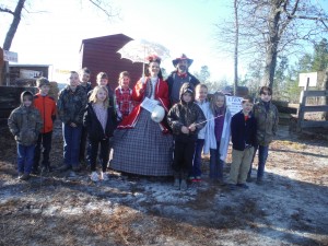 A group of home schooled children stand with Justin and Tonya Guy in period dress at the entrance to the Battle of Aiken. Pictured are left to right: Grant Rauton, Wyatt Roberson, Whit Miller, Makena Rauton, Jackson Graham, Bennett Graham, Haviland Graham, Tonya and Justin Guy, Asher Ireland, Ella Mathis Miller, Gracie Roberson, Whittaker Graham, and Knox Rauton.