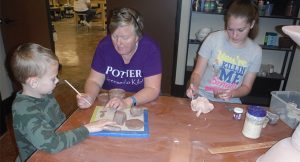 Potter and Clay Studio Manager Paula Bowers instructs Asher and his sister Chloe in a special class for homeschooled children.